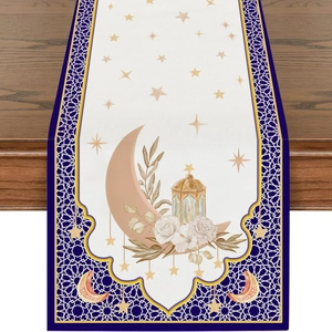 Close-up of linen table runner with crescent moon, golden lanterns, and floral patterns