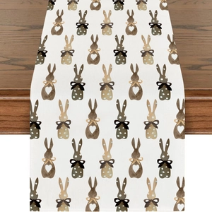 Close-up of linen table runner with watercolor bunny prints on a dark wooden table