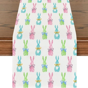 Close-up of Easter table runner with colorful bunny prints hanging over dark wood table