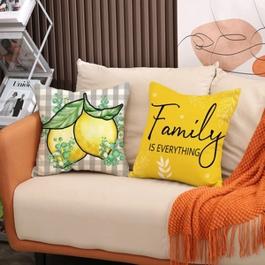 Lot de coussins à motif citron et carreaux avec citation sur un canapé en tissu