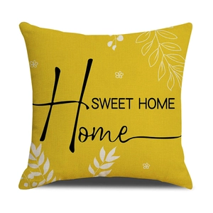 Détail de la housse de coussin jaune en coton-lin avec motif floral et texte Home