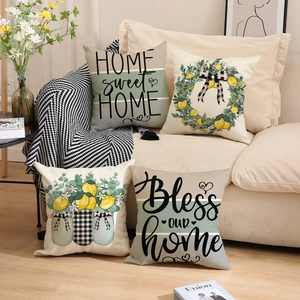 Set of 4 farm-style linen pillow covers with lemon patterns and home quotes on a sofa