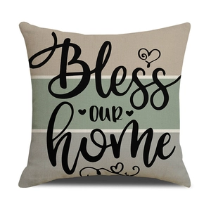 Detail of linen pillowcase with 'Bless our home' print and tricolor striped pattern