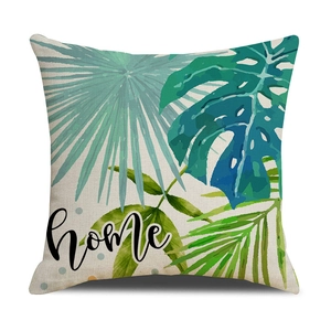 Detail of linen pillowcase with green tropical leaves pattern and 'home' art text