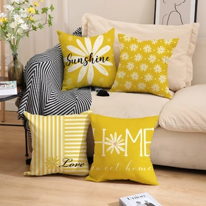 Close-up of four linen daisy pillow covers showing fabric texture on a cozy sofa