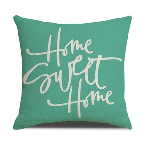 Detail of mint green linen pillow case featuring white Home Sweet Home script print