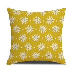 Close-up of yellow linen pillowcase featuring white daisy prints and fabric texture