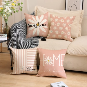 Detail of linen daisy throw pillows featuring floral patterns and script text on sofa