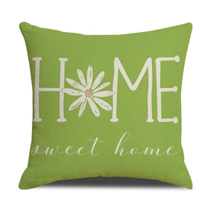 Detail of green linen pillowcase featuring HOME sweet home print and daisy floral motif