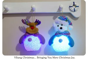Close-up of glowing LED Christmas elk and bear plush ornaments with gold hanging strings