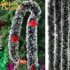 Close-up of fluffy black and silver Christmas garland with festive red bows decorations