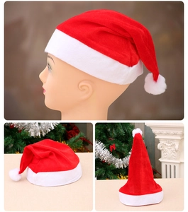 Close-up of red velvet Christmas hat with soft white plush trim and fuzzy pom-pom ball