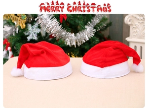 Classic red velvet Santa hats with plush white trim and fluffy pom-pom on festive background