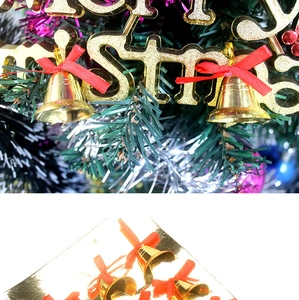Detail of 3cm golden Christmas bells with red bows hanging on a festive decorated tree