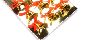Close-up of nine gold Christmas tree bells with red bows on a presentation card