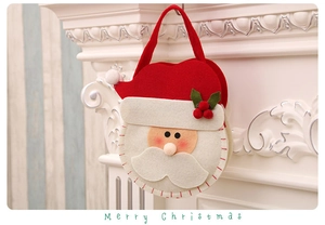 Detailed close-up of 3D Santa felt gift bag with berries hanging on a white fireplace
