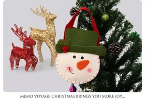 Snowman felt gift bag hanging on a Christmas tree with festive holiday decor