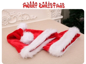 Detail of red plush Christmas hats with thick white faux fur trim and fluffy pompoms