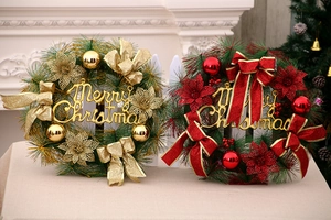 Detail view of red and gold Christmas wreaths with festive ornaments and ribbons