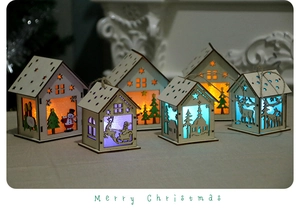 Detailed view of laser-cut wooden Christmas houses with colorful LED lights inside