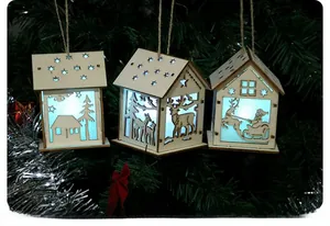 Three LED wooden Christmas house ornaments hanging on a tree with cold blue light