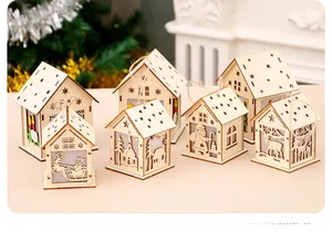 Detailed view of glowing laser-cut wooden Christmas house ornaments with reindeer patterns