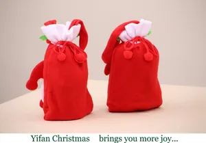 Close-up of red Christmas drawstring gift bags with soft felt texture and decorative poms