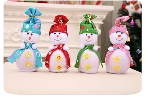 Nahaufnahme von vier Weihnachts-Schneemann-Geschenktüten in Blau, Rot, Grün und Rosa