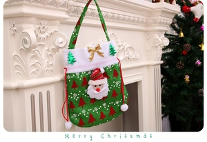 Close-up of green velvet Christmas gift bag with Santa Claus 3D patch and drawstring