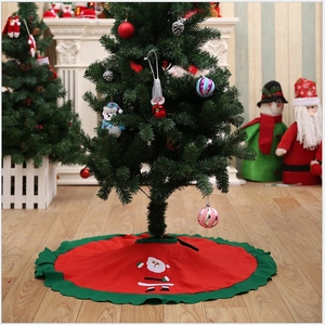 Red Christmas tree skirt with white Santa Claus pattern and green ruffled edges