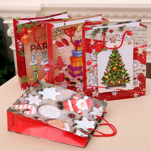Set of four Christmas kraft paper gift bags with tree, Santa and stocking motifs with handles
