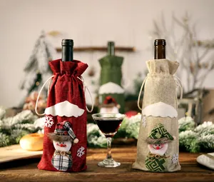Detail of burlap Christmas wine bottle bags with 3D snowman dolls and drawstring closure