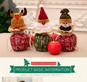 Three festive Christmas drawstring burlap bags with elk, Santa, and snowman designs and apples