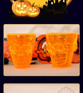 Detail of two translucent orange skull mugs with carved facial features for Halloween decor
