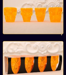 Macro shot of four orange skull-shaped shot glasses in a black decorative display box