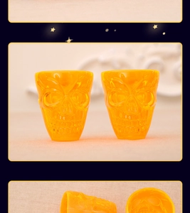 Close-up of dual transparent yellow skull-shaped shot glasses with bone textures