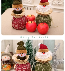 Close-up of burlap Christmas drawstring bags with Joy and Cheers holiday designs