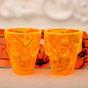 Set of two orange skull-shaped Halloween cups featuring detailed skeletal face carvings