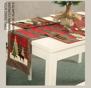 Detail eines Weihnachts-Tischläufers mit Karomuster sowie Rentier- und Baumstickerei