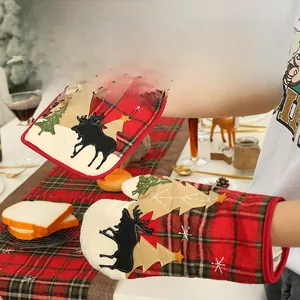 Detailed embroidery of reindeer and Christmas tree on festive plaid oven mitts