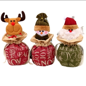 Three Christmas burlap drawstring gift bags featuring reindeer, snowman and Santa Claus characters