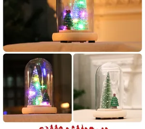 Lighted mini Christmas tree in glass dome with wood base and festive LED lights