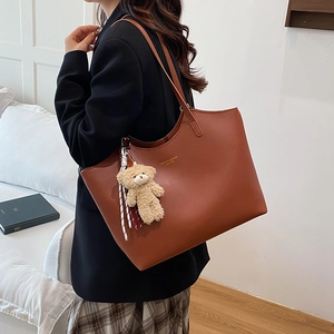 Caramel leather tote bag with teddy bear charm and gold lettering for women fashion