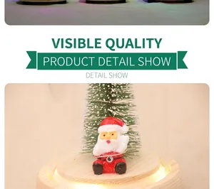 Detail of wooden base with Santa Claus and mini snowy Christmas tree under glass dome