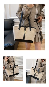 Detail of canvas tote bag with contrast leather trim and golden metal clasp for daily use