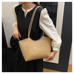 Detail of woven tote bag with herringbone pattern and long shoulder straps