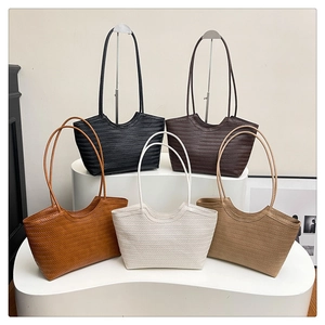 Five assorted colors of woven tote bags showing V-pattern texture and long shoulder straps