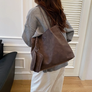 Brown faux suede oversized tote bag with a small matching pouch shown on a model