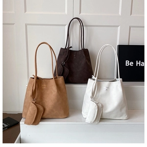 Detailed display of suede hobo bags in brown, coffee, and white with logo embossing
