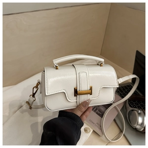 Close-up of creamy white PU leather tote with vintage copper hardware and detachable strap